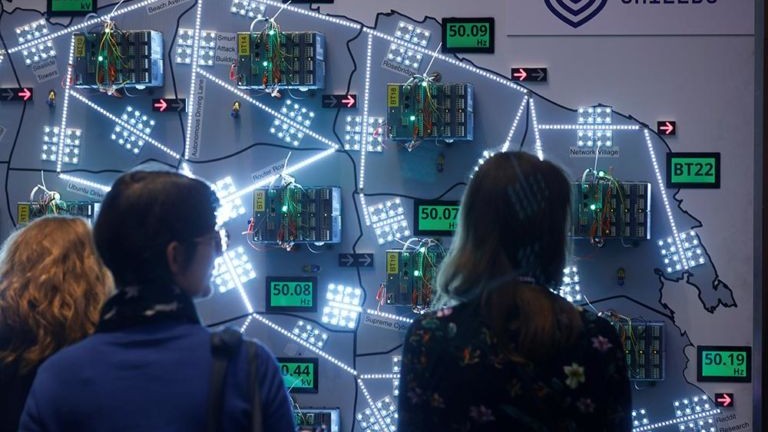 three people looking at a interactive wall installation