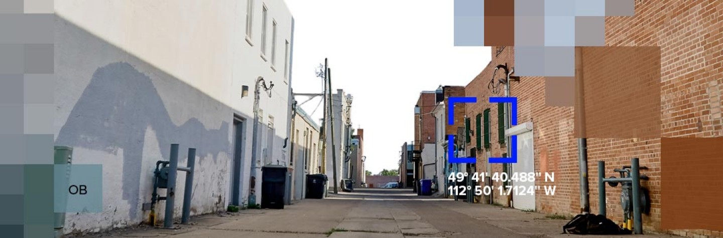 A backstreet between buildings with pixlated graphics