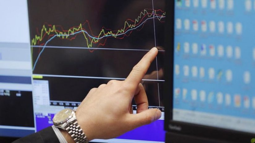 Hand pointing to a financial chart on a screen